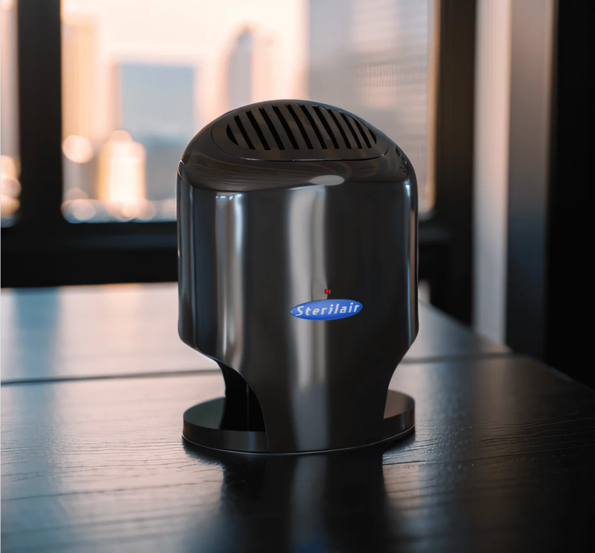 Purificador de ar Sterilair preto sobre uma mesa, em frente a uma janela
